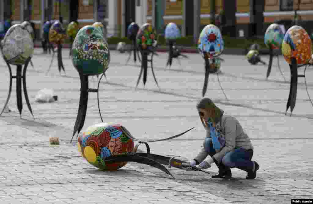 A volunteer adjusts a traditional Ukrainian Easter egg "Pysanka," as part of the upcoming Easter celebration, in central Kyiv, Ukraine.