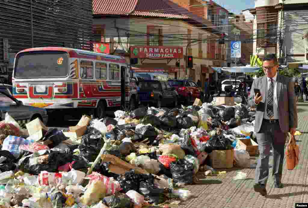 A man walks near garbage accumulated in the streets over several days since residents of the Tamborada neighborhood began blocking access to the K&#39;ara K&#39;ara landfill, because of a dispute over land prices with a local university, in Cochabamba, Bolivia, April 24, 2023.