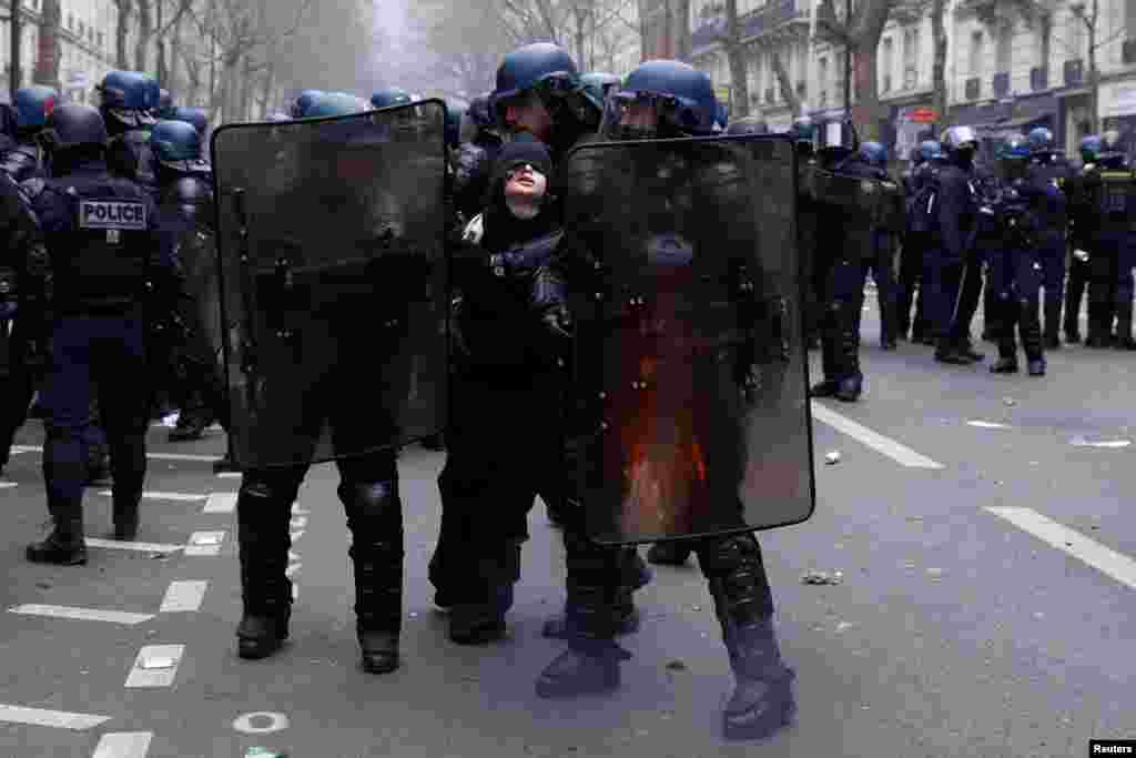 French gendarmes apprehend a protester during clashes on the tenth day of nationwide strikes and protests against French government&#39;s pension reform, in Paris.