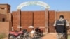 FILE - A Nigerien gendarme stands near assailants' motorcycles outside the Koutoukale prison near Niamey, following an attack on Oct. 17, 2016. Inmates escaped from the prison on July 11, 2024, though officials did not say how or how many.