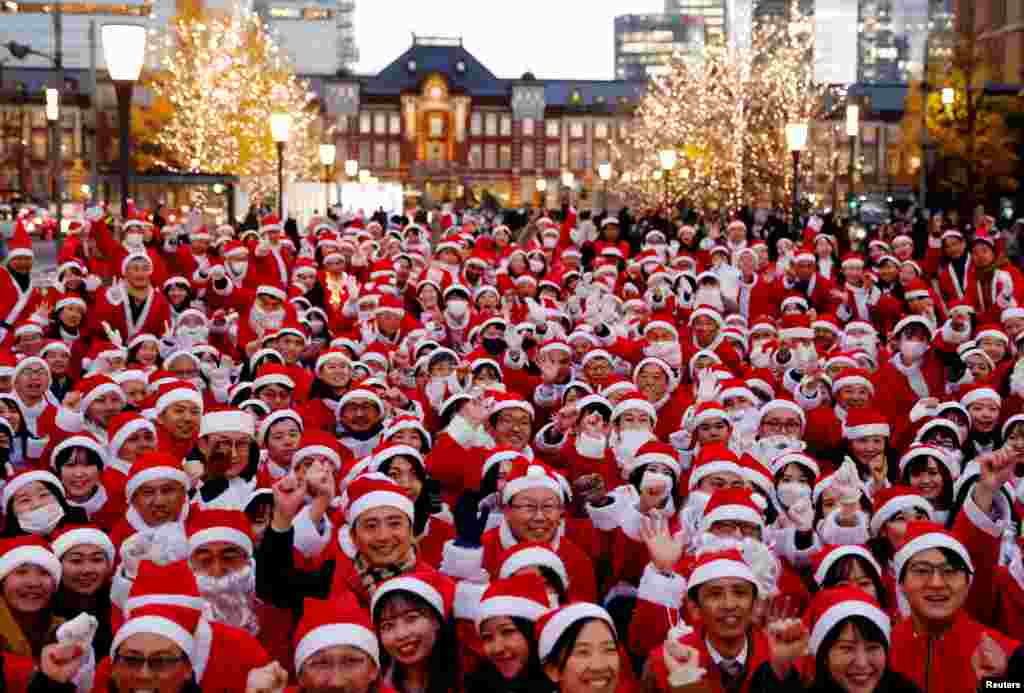 Participants wearing Santa Claus outfits pose for photos before their event to hand out gifts and clean up the street to celebrate the upcoming Christmas season in Tokyo, Japan.