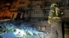 In this photo provided by the Ukrainian Emergency Service, a firefighter examines damage to an apartment building following a Russian drone attack in Dnipro, Ukraine, Feb. 23, 2024.
