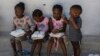 FILE - Children hold food rations at a shelter for families displaced by gang violence in the Tabarre neighborhood of Port-au-Prince, Haiti, May 19, 2024.