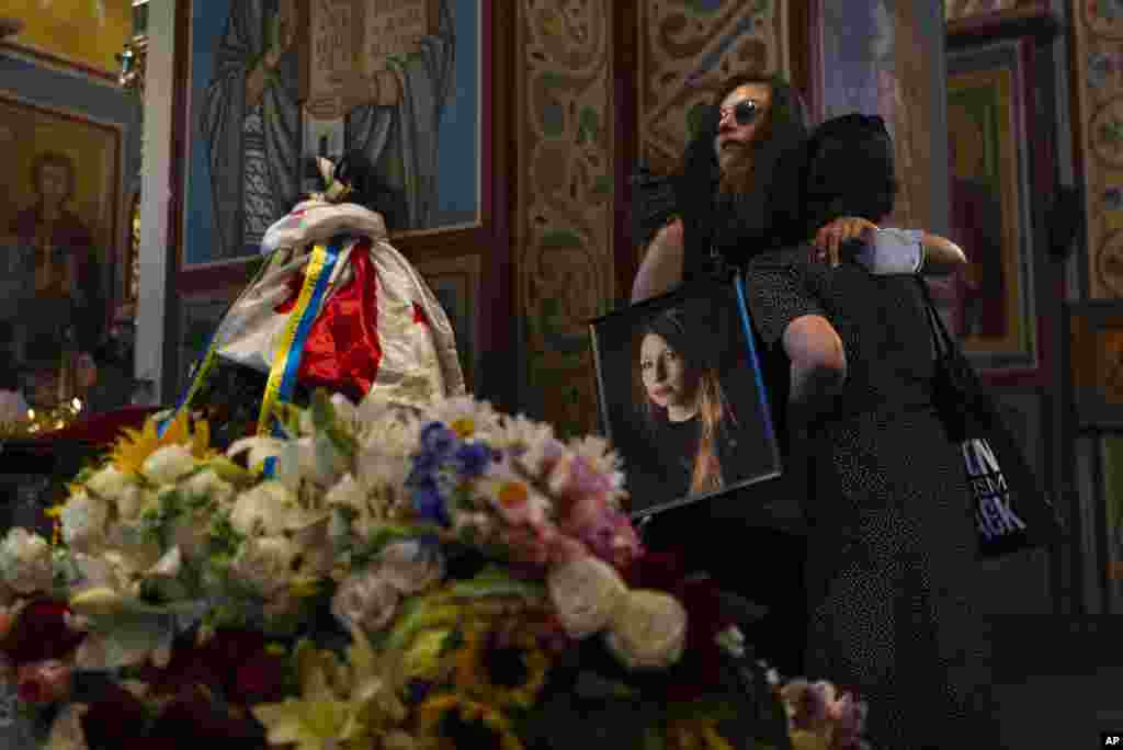 Sofia Cheliak hugs a woman during a memorial service for Ukrainian writer Victoria Amelina in Kyiv.&nbsp;The award-winning writer died from her injuries after the June 27 Russian missile strike on a popular restaurant frequented by journalists and aid workers in eastern Ukraine.
