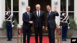 ເລຂາທິການໃຫຍ່ອົງການ NATO ທ່ານເຈັນ ສະໂຕລເ​ຕັນເບີກ ຊ້າຍ ແລະ ນາຍົກລັດ​ຖະມົນຕີໂຮນ​ລັງ ທ່ານມາກ ຣຸດເຕ ຂວາ ຕ້ອນຮັບປະທານາທິບໍດີລີທົວເນຍ ທ່ານ ຈີຕານາສ ໂນເຊດາ ທີ່ນະຄອນເຮກ ເນເທີແລນ ວັນທີ 27 ມິຖຸນາ 2023. 