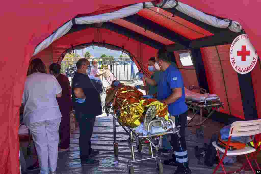 A survivor receives first aid after a rescue operation at the port in Kalamata, about 240 kilometers southwest of Athens, Greece.&nbsp;Authorities say at least 70 people have died and dozens are feared missing off the coast of southern Greece after a fishing boat carrying migrants capsized and sank.