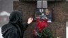 FILE — A woman touches a photo of Alexey Navalny at the Memorial to Victims of Political Repression in St. Petersburg, Russia, Feb. 17, 2024. At least four journalists were detained in Russia last week while reporting on gatherings to mourn Navalny's death, according to reports. 