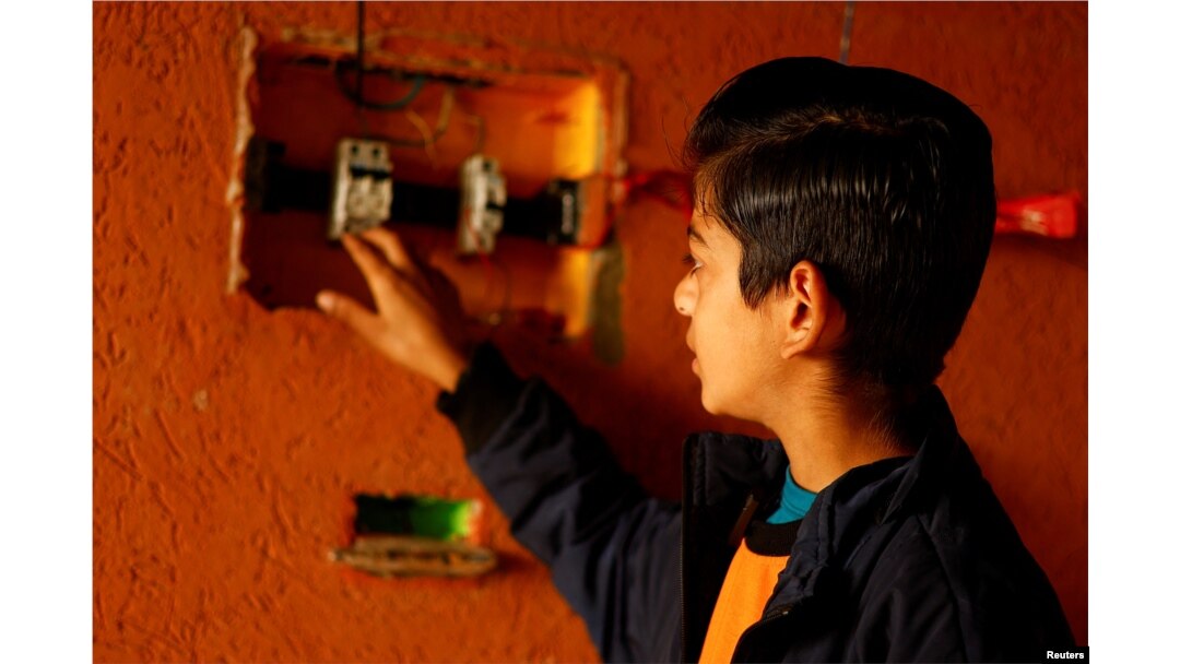 Displaced Palestinian teenager Hussam Al-Attar, nicknamed by people 'Newton', shows an electrical panel at a tent camp in Rafah, in the southern Gaza Strip, February 6, 2024. (REUTERS/Ibraheem Abu Mustafa)