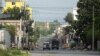 A Haitian National Police car and an armored vehicle drive through a desolated street in the Champ de Mars neighborhood, in Port-au-Prince, Haiti, June 27, 2024. The Biden administration is offering deportation relief to Haitians in the U.S., because of security issues in Haiti.
