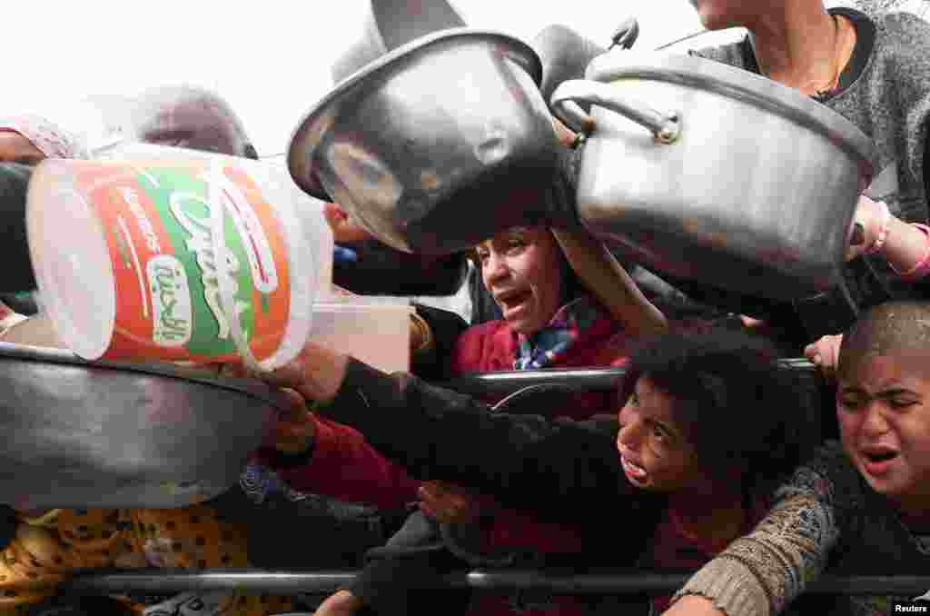 Palestinian children wait to receive food cooked by a charity kitchen amid shortages of food supplies in Rafah in the southern Gaza Strip, Feb. 13, 2024,&nbsp;as the ongoing conflict between Israel and the Palestinian Islamist group Hamas continues.