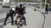 A police officer pats down a motorcyclist at a checkpoint in Port-au-Prince, Haiti, July 1, 2023. 