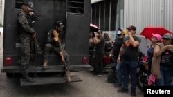FILE - A truck with detainees passes by relatives of people detained during protests in Venezuela over the country's contested presidential election, in Caracas, Venezuela, Aug. 1, 2024. 