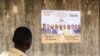 Mpiga kura kijana akitizama bango la kampeni lenye picha za wagombea wa uchaguzi wa bunge wa muungano wa vyama madarakani (DMP), mjini Lome, Aprili 24, 2024. Picha ya AFP