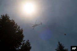 Helikopter prenosi vodu iznad Park Fire u blizini Forest Rancha, Kalifornija, 30. jula 2024.