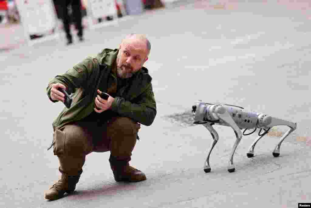 A man takes a picture with a robot at the Mobile World Congress (MWC) in Barcelona, Spain, Feb. 27, 2023. 