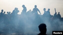 Palestinci se okupljaju na mestu izraelskog udara na kamp interno raseljenih ljudi u Rafahu, 27. maja 2024.