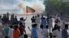 FILE - Supporters of Pakistan's former Prime Minister Imran Khan block a road as police fire tear gas to disperse them during a protest in support of Khan in Karachi, Pakistan, May 9, 2023. 