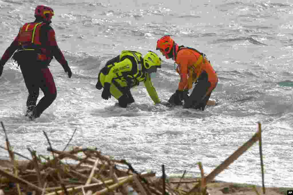 Rescuers recover a body after a migrant boat broke apart in rough seas, at a beach near Cutro, southern Italy.&nbsp;A wooden boat crowded with migrants smashed into rocky reefs and broke apart before dawn off the Italian coast. Rescuers had recovered nearly 60 bodies, and dozens more people were missing in the turbulent water.&nbsp;