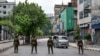 Bangladesh soldiers stand guard along the street following a curfew and the deployment of military forces in Dhaka on July 20, 2024, after days of clashes during protests against government job quotas across the country.