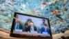 U.N. High Commissioner for Human Rights Volker Turk, center, is seen on a TV monitor speaking during a session of the 52nd U.N. Human Rights Council, in Geneva, on March 6, 2023. 
