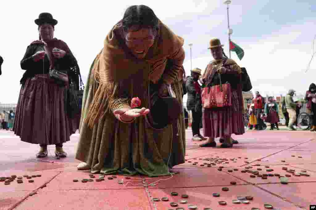 An Aymara woman plays with a spinning top during activities commemorating the anniversary of the founding of the city of El Alto, Bolivia, March 5, 2023. 