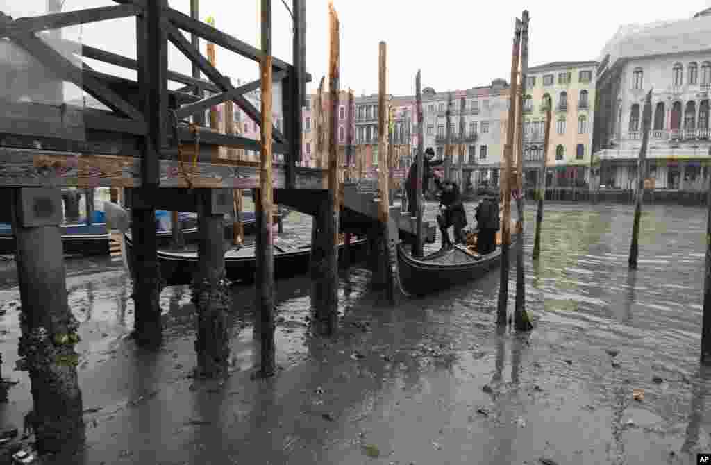 Passengers get off a gondola docked along a canal during a low tide in Venice, Italy.&nbsp;Some of Venice&#39;s secondary canals have practically dried up lately due a prolonged spell of low tides linked to a lingering high-pressure weather system.