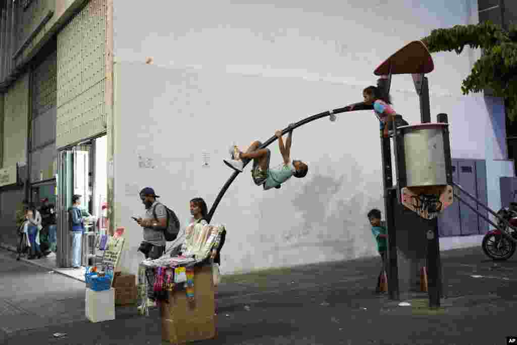 Children play on a small jungle gym along Sabana Grande boulevard in Caracas, Venezuela, March 1, 2023. 