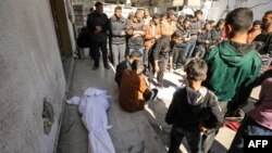 Palestinians mourn near bodies at Kamal Edwan Hospital in Beit Lahia, in the northern Gaza Strip, on Feb. 29, 2024, after Israeli soldiers allegedly opened fire at Gaza residents who rushed towards trucks loaded with humanitarian aid .