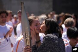 Francuska ministrica sporta Amelie Oudea-Castera, desno, ljubi Mariju Vysotchansku iz Ukrajine u obraz tokom štafete olimpijske baklje u Marseilleu, južna Francuska, 9. maja 2024.
