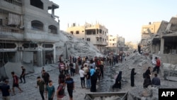 Palestinci se okupljaju da provjere zgradu ubrzo pošto je srušena izraelskim bombardovanjem u izbegličkom kampu Nuseirat u centralnom pojasu Gaze, 22. augusta 2024.