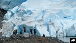 FILE - A group of people take in the views of the Mendenhall Glacier on June 8, 2023, in Juneau, Alaska.