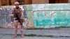 FILE - An Iraqi army soldier stands next to graffiti left by an affiliate of the Kurdistan Workers' Party, or PKK, in Sinjar, Iraq, Dec. 4, 2020. Turkish airstrikes killed 17 members of the outlawed group, the defense ministry said Aug. 12, 2024.