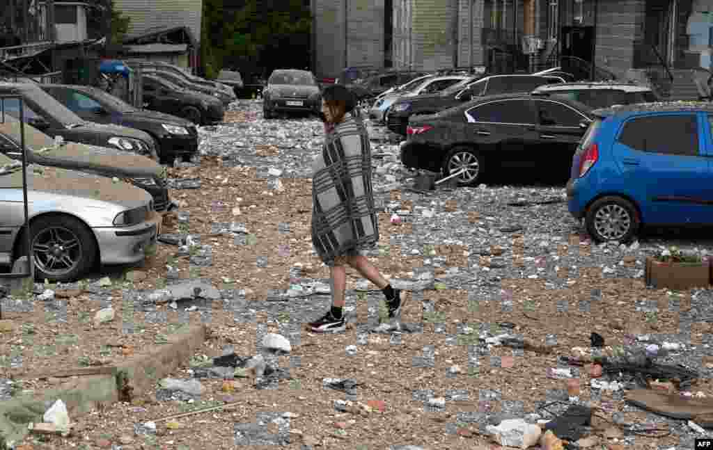 A local resident walks among damaged cars while leaving a multi-story residential building, partially destroyed after night drone attacks in Kyiv, Ukraine.&nbsp;Ukraine said it had downed 29 out of 31 drones, mainly over Kyiv and the Kyiv region in the latest Russian barrage - the third on the capital in 24 hours.