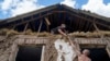 People cover a roof with tarps after their house was hit by a Russian airstrike near the Russian-Ukrainian border in Sumy region, Ukraine, Aug. 15, 2024.