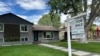 FILE - A for sale sign stands outside a single-family home in Englewood, Colorado, June 27, 2024. 