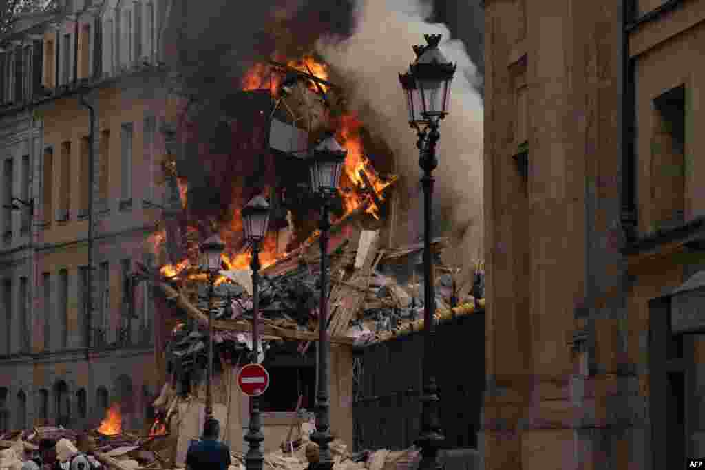 Smoke billows from the rubble of a building at Place Alphonse-Laveran in the 5th arrondissement of Paris.&nbsp;A major fire of unknown origin broke out in a building in central Paris, part of which collapsed, injuring at least one person.