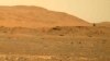 Slika koju je 30. aprila 2021., napravio rover Mars Perseverance prikazuje helikopter Ingenuity, desno, kako leti iznad površine. Podaci prikupljeni sa planete ukazuju da bi ispid površine moglo biti dosta vode. (NASA preko AP)