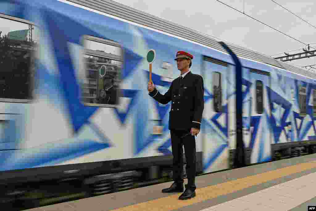 A station master holds a signaling disc as the first train since a deadly train disaster leaves from Athens&#39; main station to Thessaloniki, Greece.&nbsp;Five weeks after the train disaster that killed 57 people, the rail link between Athens and Thessaloniki, the second-largest city in northern Greece, has partially resumed.&nbsp;