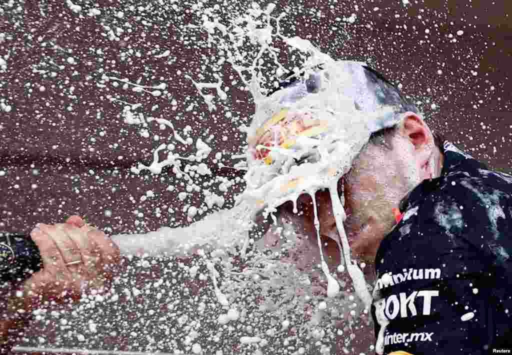 Red Bull&#39;s Max Verstappen celebrates with champagne on the podium after winning the Monaco Grand Prix in Monte Carlo.