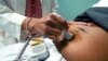 FILE - A doctor uses a hand-held probe on a pregnant woman to measure the heartbeat of her fetus, in Jackson, Mississippi, Dec. 17, 2021.