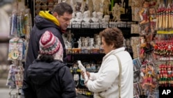 A vendor sells souvenirs of of Michelangelo's 16th century statue of David at a kiosk in Florence's central Piazza della Signoria, Italy, March 18, 2024.