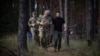 In a photo posted on his X account on July 29, 2024, Ukrainian President Volodymyr Zelenskyy, right, walks with military officials in an area identified as near Vovchansk, in Ukraine's Kharkiv region. The face of the official in the center has been blurred at the source.