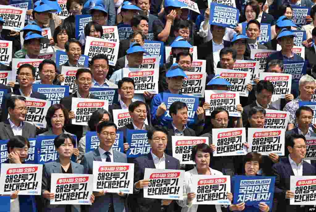 South Korea&#39;s main opposition Democratic Party lawmakers and party members hold placards reading &quot;We oppose the dumping of Fukushima contaminated water into the sea&quot; during a rally against Japan&#39;s plan to release treated water from the Fukushima nuclear plant, at the National Assembly in Seoul.