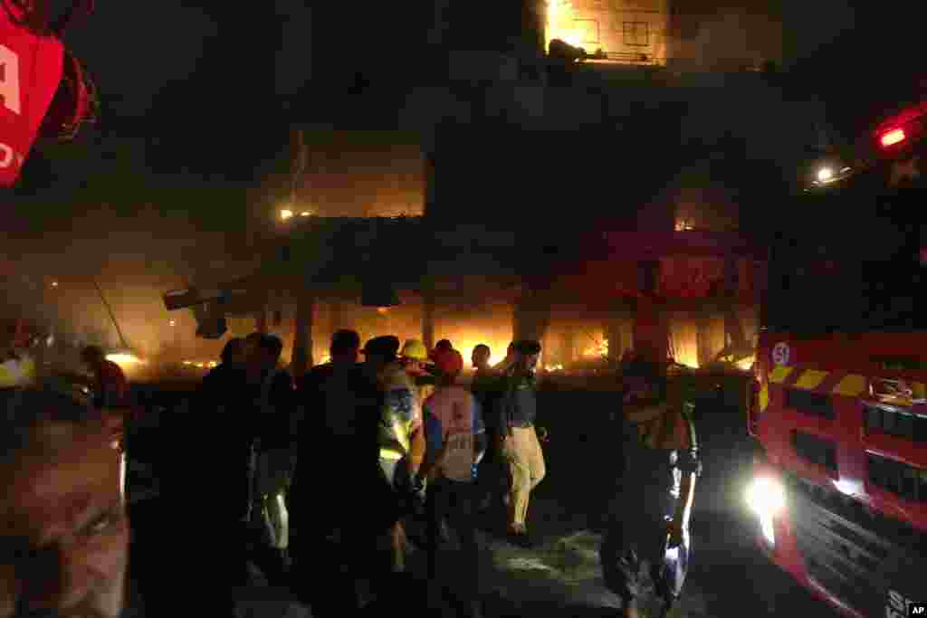 Firefighters struggle to contain a fire at a multi-story commercial building in Karachi, Pakistan.&nbsp;The massive fire broke out in the largest southern port city, killing a number of people and damaging several shops, police and rescue officials said.&nbsp;