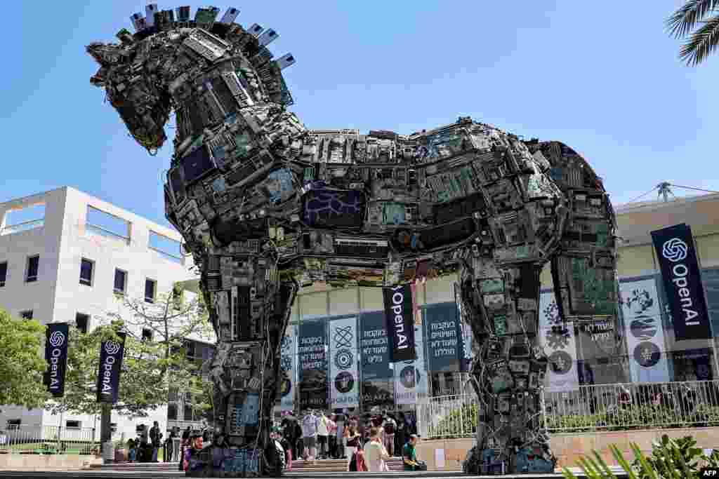 Banners of U.S. artificial intelligence company OpenAI fly near an installation depicting the legendary &quot;Trojan horse&quot; built entirely out of microelectronic circuit boards and other computer components,&nbsp;outside at the campus of Tel Aviv University in Tel Aviv, Israel.