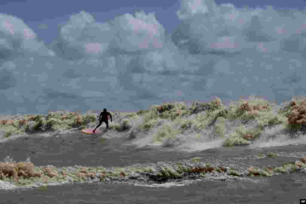 Brazilian surfer Naysson Costa rides the tidal bore wave known as &quot;Pororoca,&quot; during the Amazon Surf Festival held in the Canal do Perigoso, or &quot;Dangerous Channel,&quot; at the mouth of the Amazon River near Chaves, Marajo Island archipelago, Para state, Brazil, June 5, 2023. T