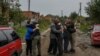 Neighbors embrace each others after they return from evacuation to the liberated village of Kamianka in the Kharkiv region, Ukraine, Oct. 2, 2022. 