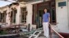 FILE - A physician stands in front of a therapy department which was destroyed in a Russian attack on a hospital in Zolochiv, Kharkiv region, Ukraine, July 31, 2022.