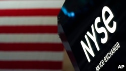 FILE - An NYSE sign is seen on the floor at the New York Stock Exchange in New York, June 15, 2022. 