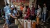 Warga antre membeli minyak goreng murah dari operasi pasar di Surabaya, Jawa Timur, 18 Februari 2022. (Foto: Juni Kriswanto/AFP)